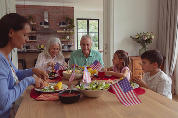 Multi-generation family having food on dining table at home