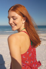 Naklejka premium Redhead woman standing on the beach