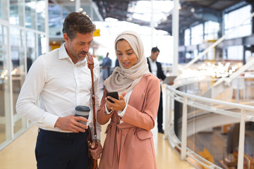 Business people discussing over mobile phone in a modern office