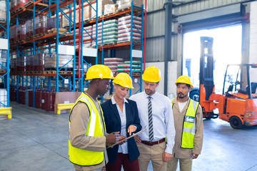 Diverse staffs working together on clipboard in warehouse