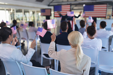 Business people waving an American flag in business seminar