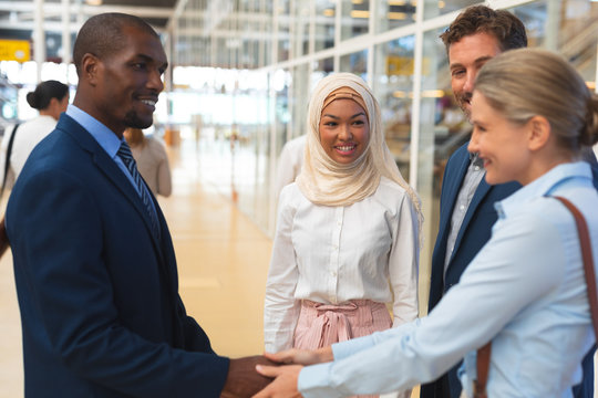 Business people interacting with each other in corridor at office