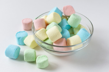 Colored marshmallows in a plate on a white background. A plate full of sweets.