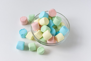 Colored marshmallows in a plate on a white background. A plate full of sweets.