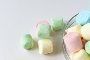 Colored marshmallows in a plate on a white background. A plate full of sweets.