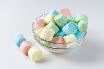 Colored marshmallows in a plate on a white background. A plate full of sweets.