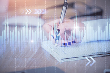 Multi exposure of hands making notes with forex chart huds. Stock market concept.