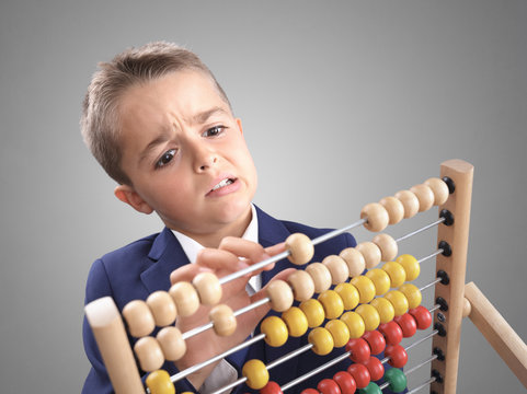 Young boy accountant businessman does calculation on a abacus