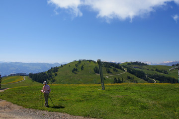 Fototapeta na wymiar A senior is walking in Scheffau on the Kaiser Mountains, Tyrol - Austria