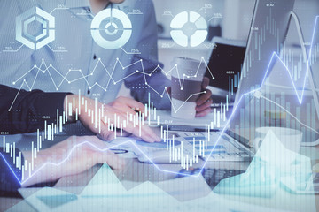 Multi exposure of chart with man typing on computer in office on background. Concept of hard work.