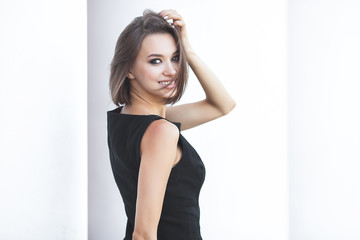 Closeup portrait of young attractive woman in black dress. Beautiful lady outdoors. - obrazy, fototapety, plakaty