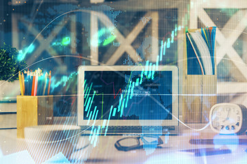 Double exposure of chart and financial info and work space with computer background. Concept of international online trading.
