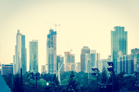 Building Under Construction With Working Cranes In Downtown Chicago At Sunset