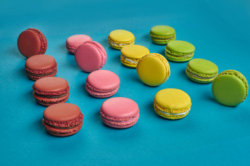 Colored macaron or macaroon, sweet meringue-based confection on blue background. Close-up, copy space.