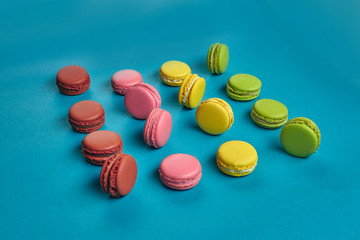 Colored macaron or macaroon, sweet meringue-based confection on blue background. Close-up, copy space.