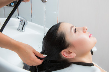 young beautiful woman wash their hair in a beauty salon