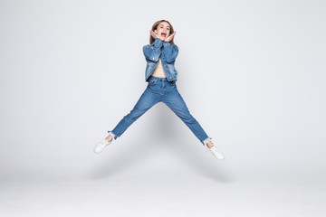 Jumping young woman in jeans on white background