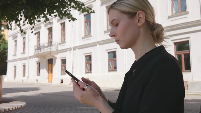 Successful caucasian business woman sitting on old town square use smartphone in social internet media 5g technology