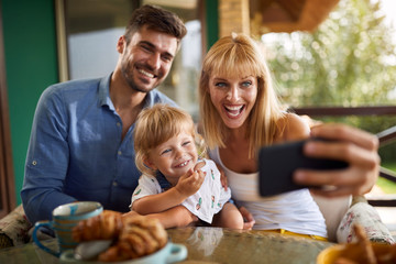 Cheerful family making selfie together