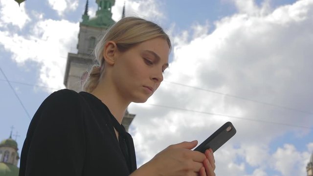 Close up caucasian business woman sitting on old town square use smartphone in social internet media 5g technology