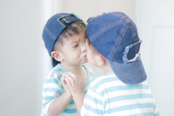 Cute little boy looking at mirror , kid self talk via mirror , play with salt