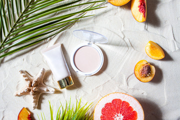 Charming beach. Decorative cosmetics in pastel colors, powder, base, lip gloss lie on the white...