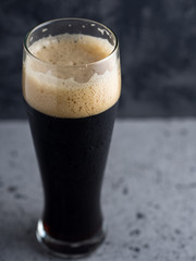A glass of dark beer on a dark background . Dark strong coffee porter