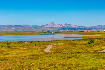 Naklejka premium Lake on Iceland with volcanic landscae in background
