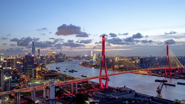 Time lapse of Shanghai cityscape and city skyline with clouds moving, sunset time, cargo ships sailing under Yangpu bridge, 4k footage.