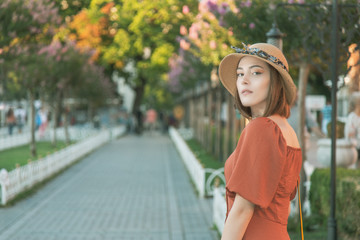 Beautiful girl with orange colored dress posing with Hagia Sophia during sunset from Istanbul