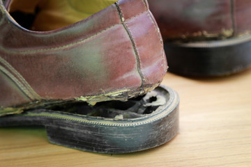 Fototapeta na wymiar Old broken shoes from long using 