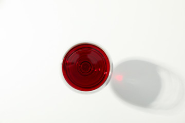 Glass with red wine on white background, top view