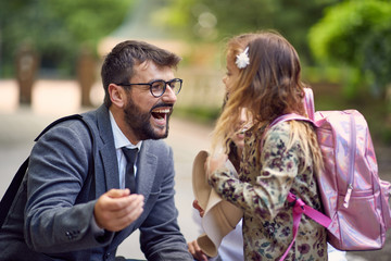 happy dad ready to hug a little schoolgirl