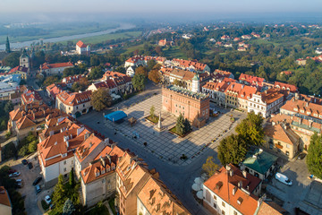 Fototapeta na wymiar Aerial skyline panorama of Sandomierz old city, Poland, in sunrise light. Old town with market square, Gothic city hall, medieval castle on the left and Vistula River in morning fog in the background