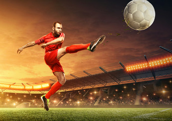Soccer player in action on a stadium. Kicking the ball. Soccer game. Sports championship. Soccer field. - obrazy, fototapety, plakaty
