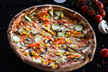Fototapeta na wymiar fresh italian pizza with vegetables - tomatoes, pumpkin, onion, corn & delicious cheese