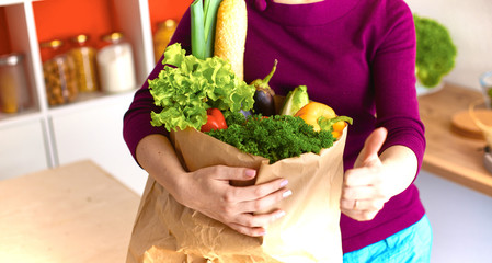 Healthy positive happy woman holding a paper shopping bag full