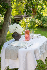 Table set in garden with white peonies