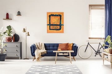 Yellow and blue painting hanging on white wall in bright living