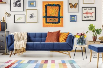 Painting above navy blue couch in artistic living room interior