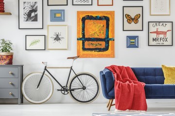 Bright red blanket on a navy blue settee standing next to a vint