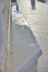 Mirror image of the cathedral in a wet stone bench