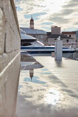 Mirror image of the cathedral in a wet stone bench