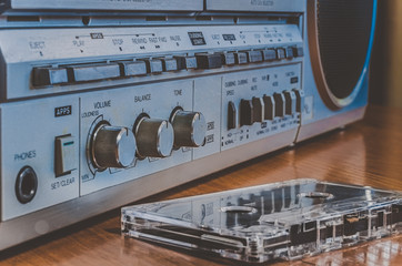 Audio cassette in front of a tape recorder. Eye level shooting. Soft focus. Retro style.