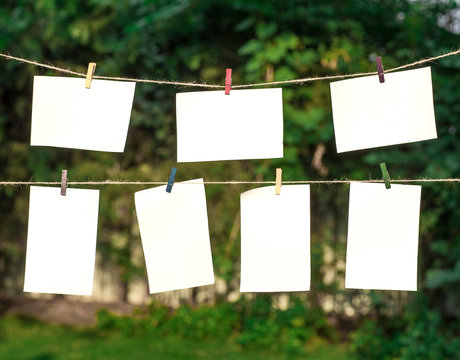 Blank photos hanging on a clothesline in summer