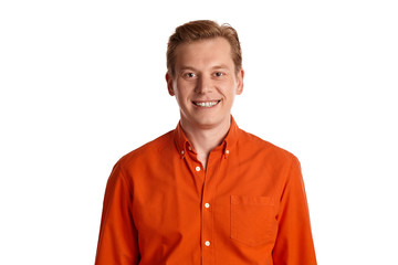 Close-up portrait of a ginger guy in orange shirt posing isolated on white background. Sincere emotions.