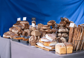Artisan bread stall at food market, loaves of bread for sale.