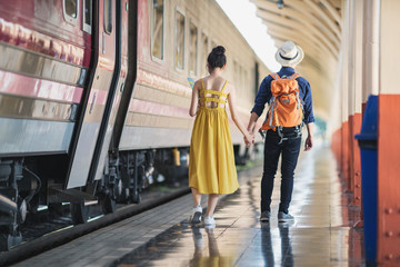 Couple of tourists near the train. Travelling together by train.	