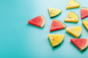 Slices of fresh pieces of yellow and red watermelon on a blue background. Free place.