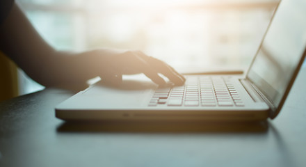 Woman using laptop work on desk vintage tone, soft focus